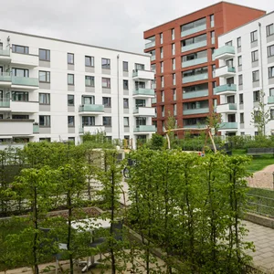 Blick in den Innenhof einer neuen Wohnanlage mit Grünfläche und Kinderspielplatz am Stadtpark.