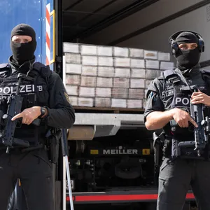 Schwer bewaffnete Polizisten bewachen sichergestelltes Kokain. Die Drogenbanden schleusen immer größere Mengen nach Europa.