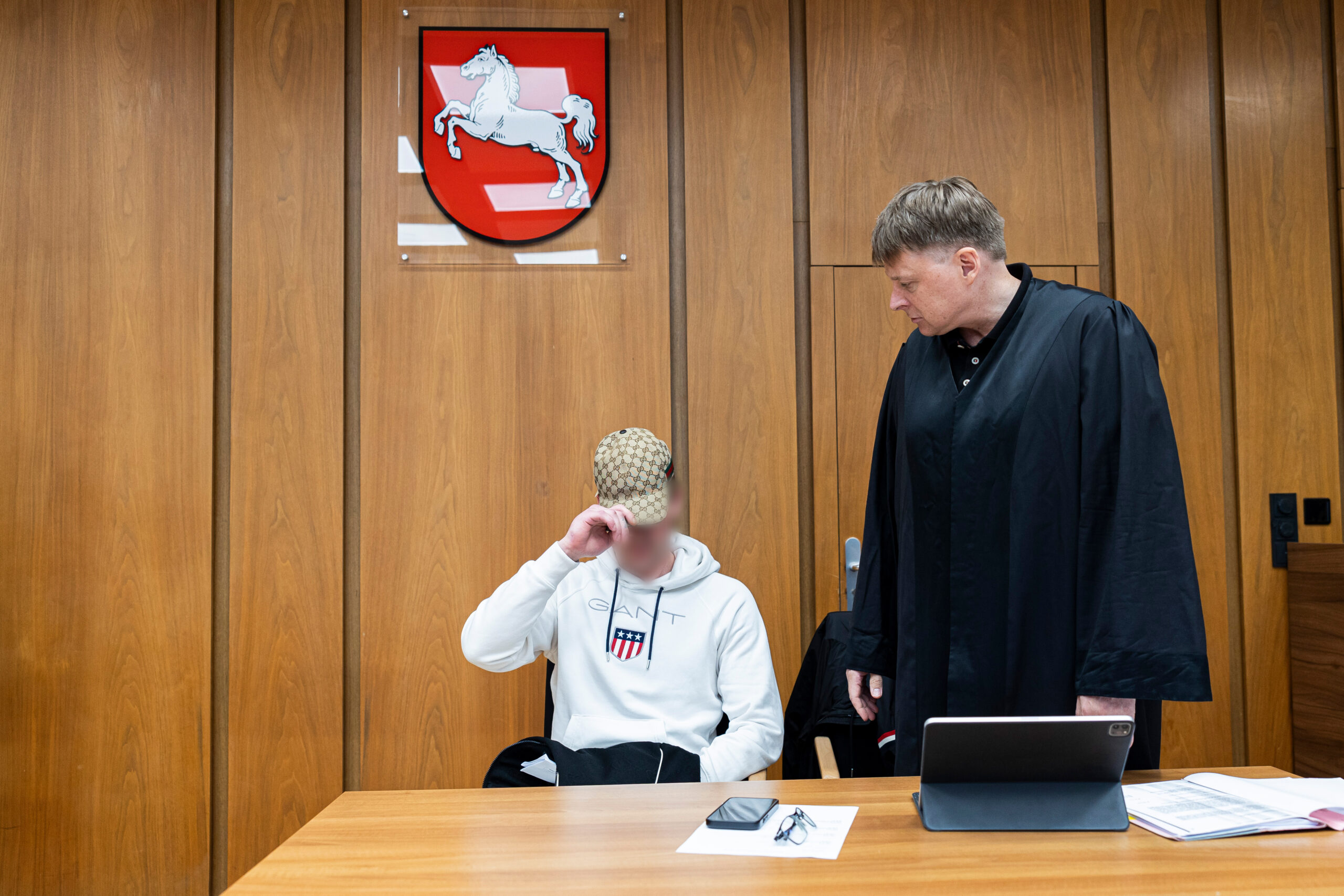 Der Angeklagte (l.) sitzt vor Verhandlungsbeginn in einem Gerichtssaal im Amtsgericht Lehrte. Daneben steht sein Anwalt Christoph Rautenstengel.