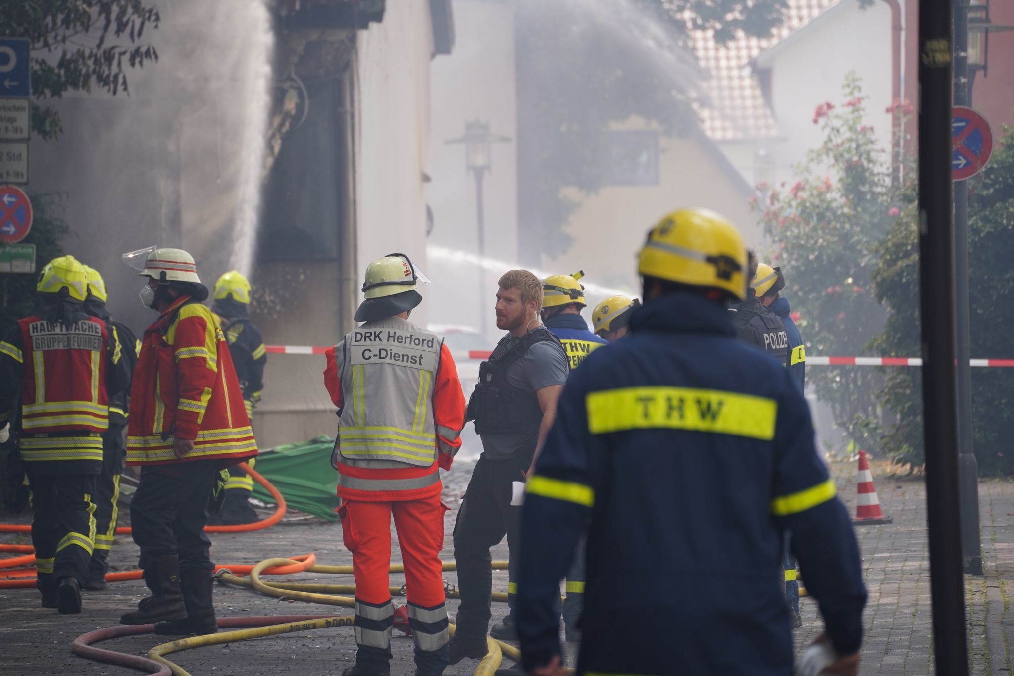 Einsatzkräfte von Feuerwehr und THW stehen am Unglücksort.