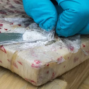 Ein Zollbeamter präsentiert in Hamburg eine Messerspitze der Droge Kokain aus einem sichergestellten Paket.
