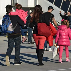 Familie steigt in ein Flugzeug.