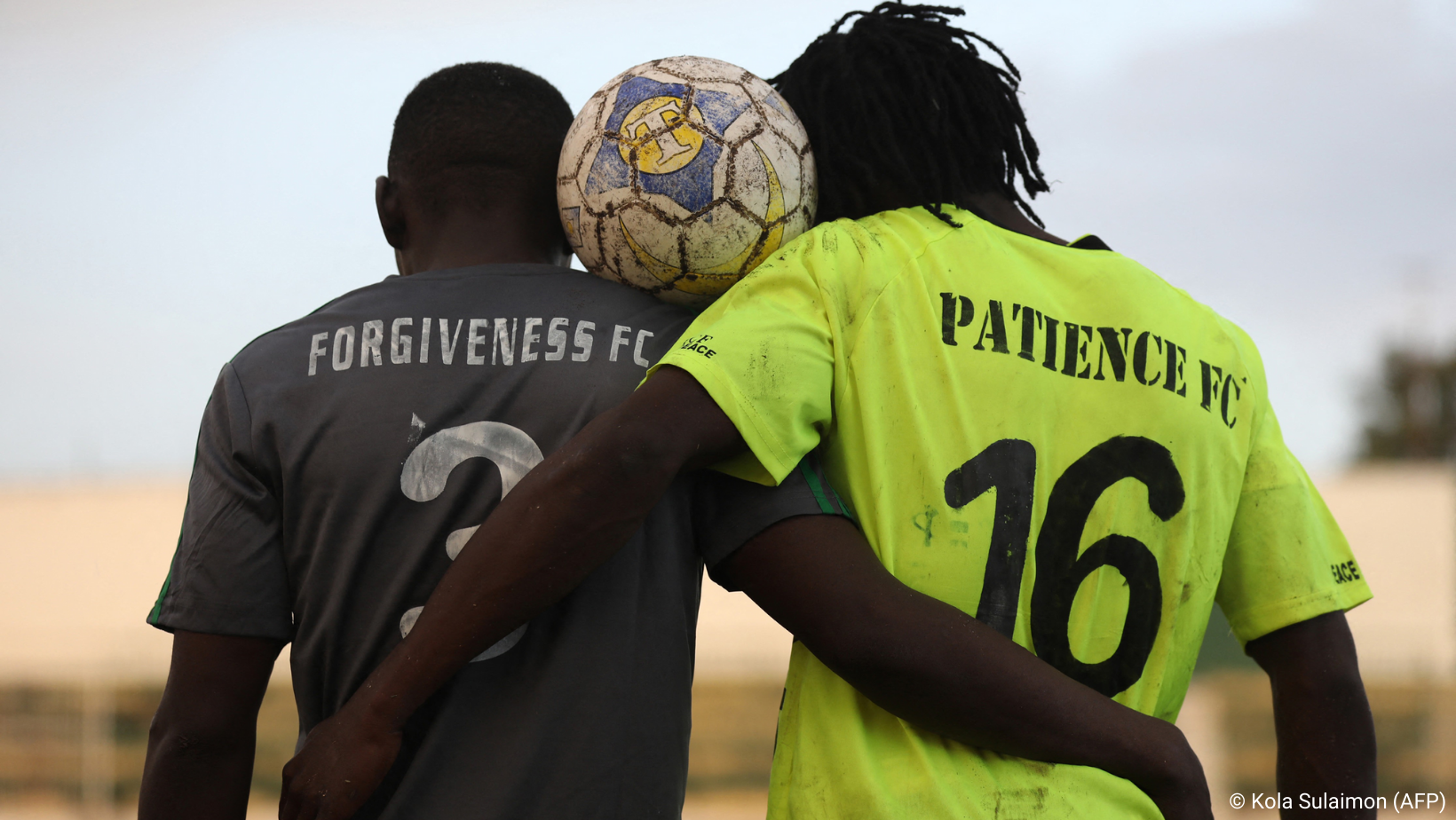 Zwei Fußballspieler tragen Trikots mit der Aufschrift „Forgiveness FC“ und „Patience FC“