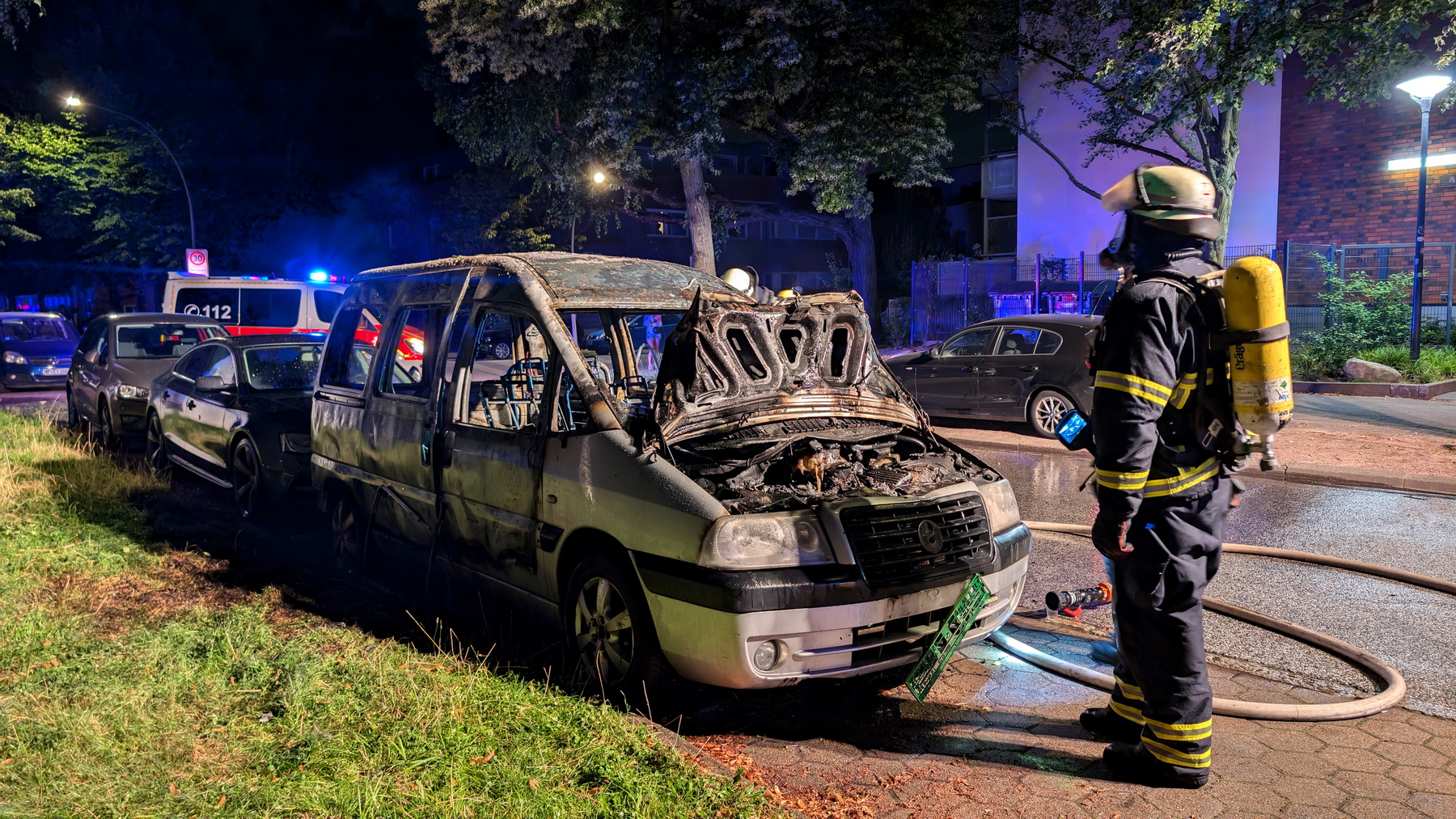 Feuerwehrkraft an einem ausgebrannten Autowrack