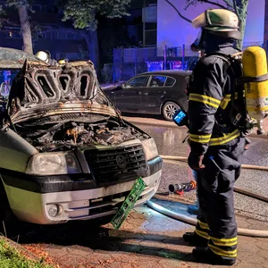 Feuerwehrkraft an einem ausgebrannten Autowrack