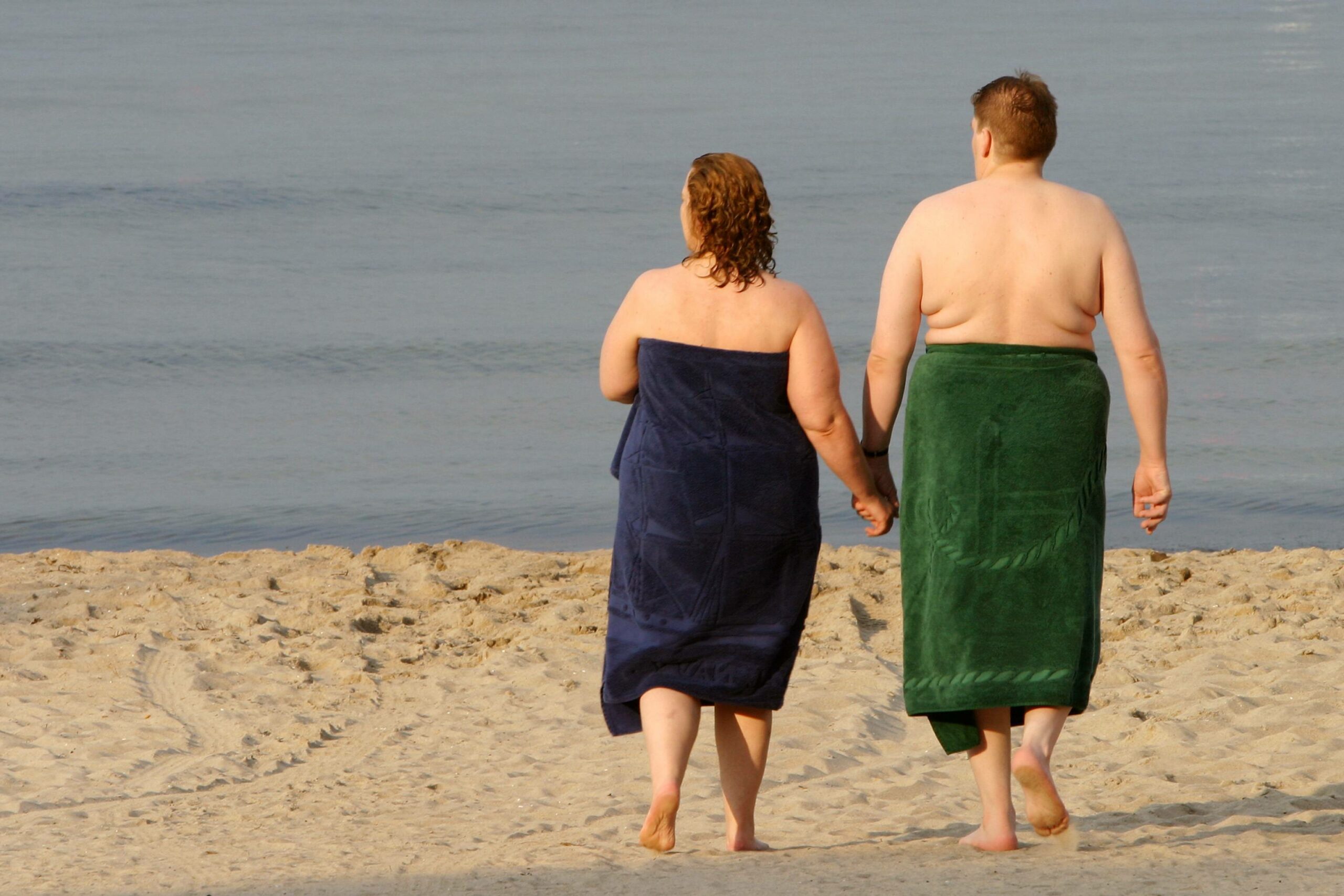 Paar in Handtüchern am Strand