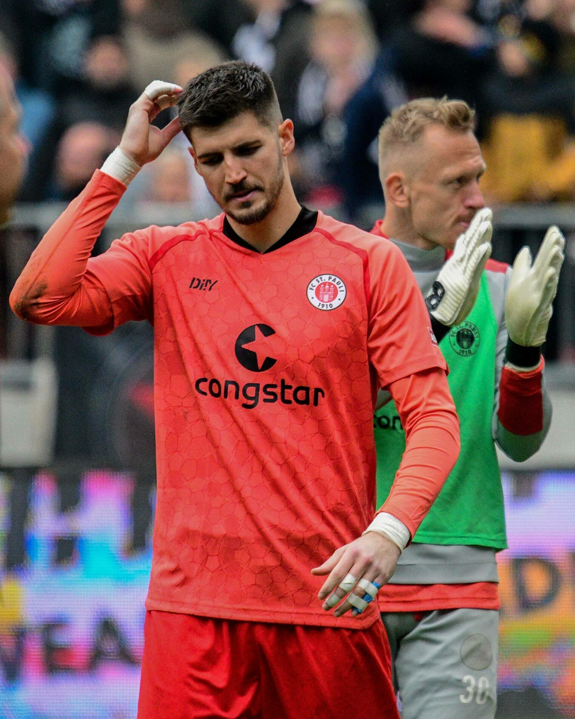 St. Pauli-Torwart Nikola Vasilj kartzt sich nachdenklich am Kopf