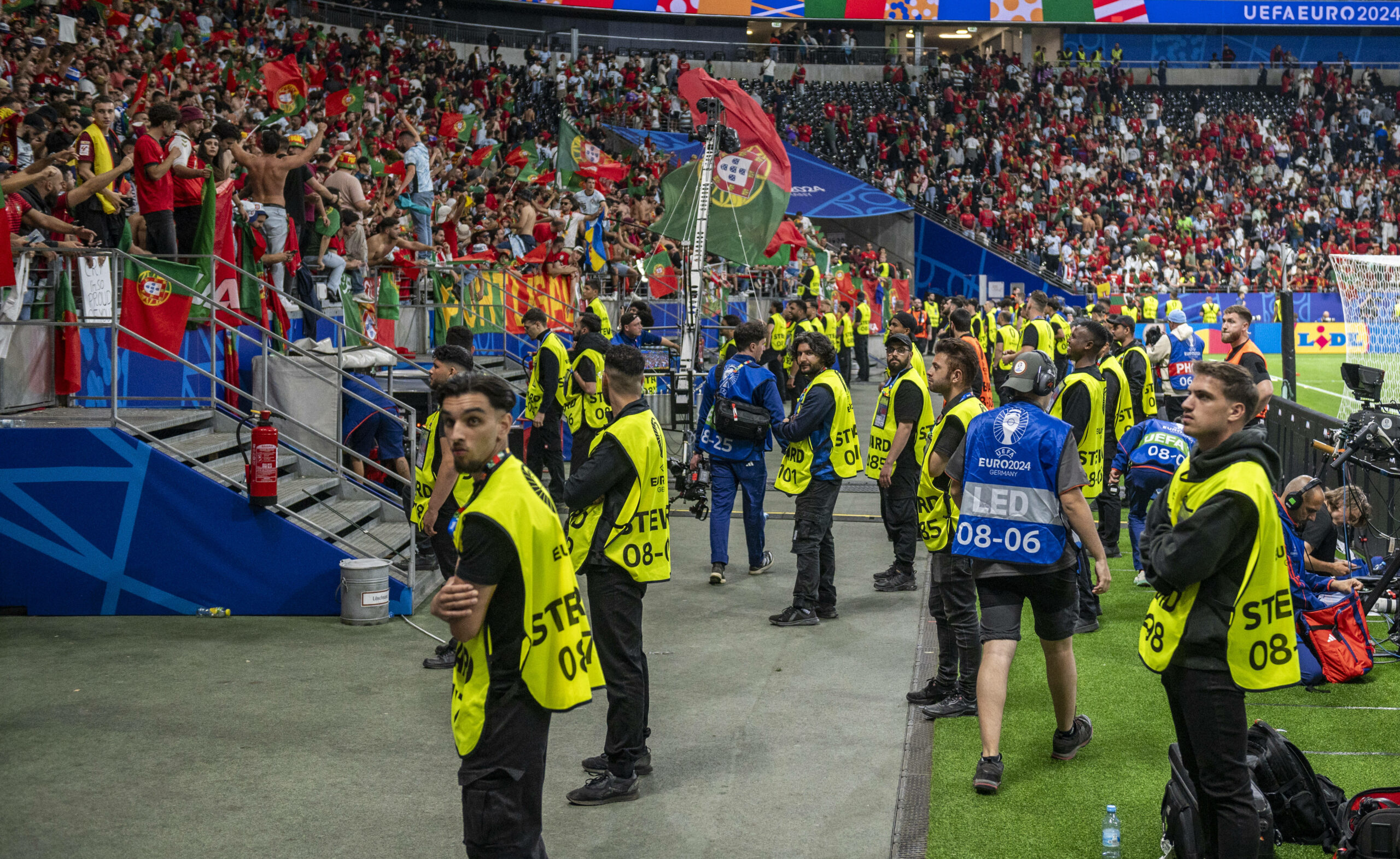 Ordner stehen vor der Tribüne, während eines EM-Spiels