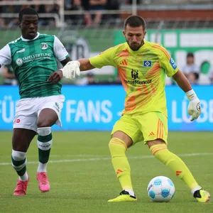 HSV-Keeper Daniel Heuer Fernandes klärt den Ball vor Lübecks Stürmer Herdi Bukusu