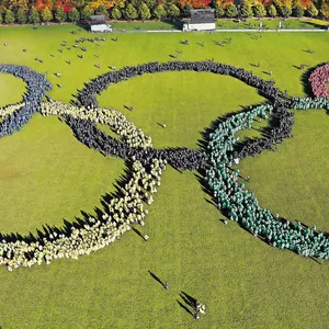 Bunt gekleidete Hamburger bilden im Stadtpark die fünf Olympischen Ringe.