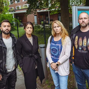 Zwei Elternpaare vor einem Kita-Gelände