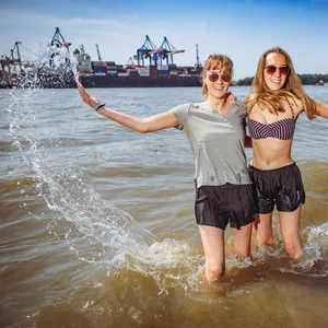Die Zwillingsschwestern Jule (19,l.) und Susann kühlen sich am Elbstrand ab – am Wochenende werden sie viele Nachahmer finden.