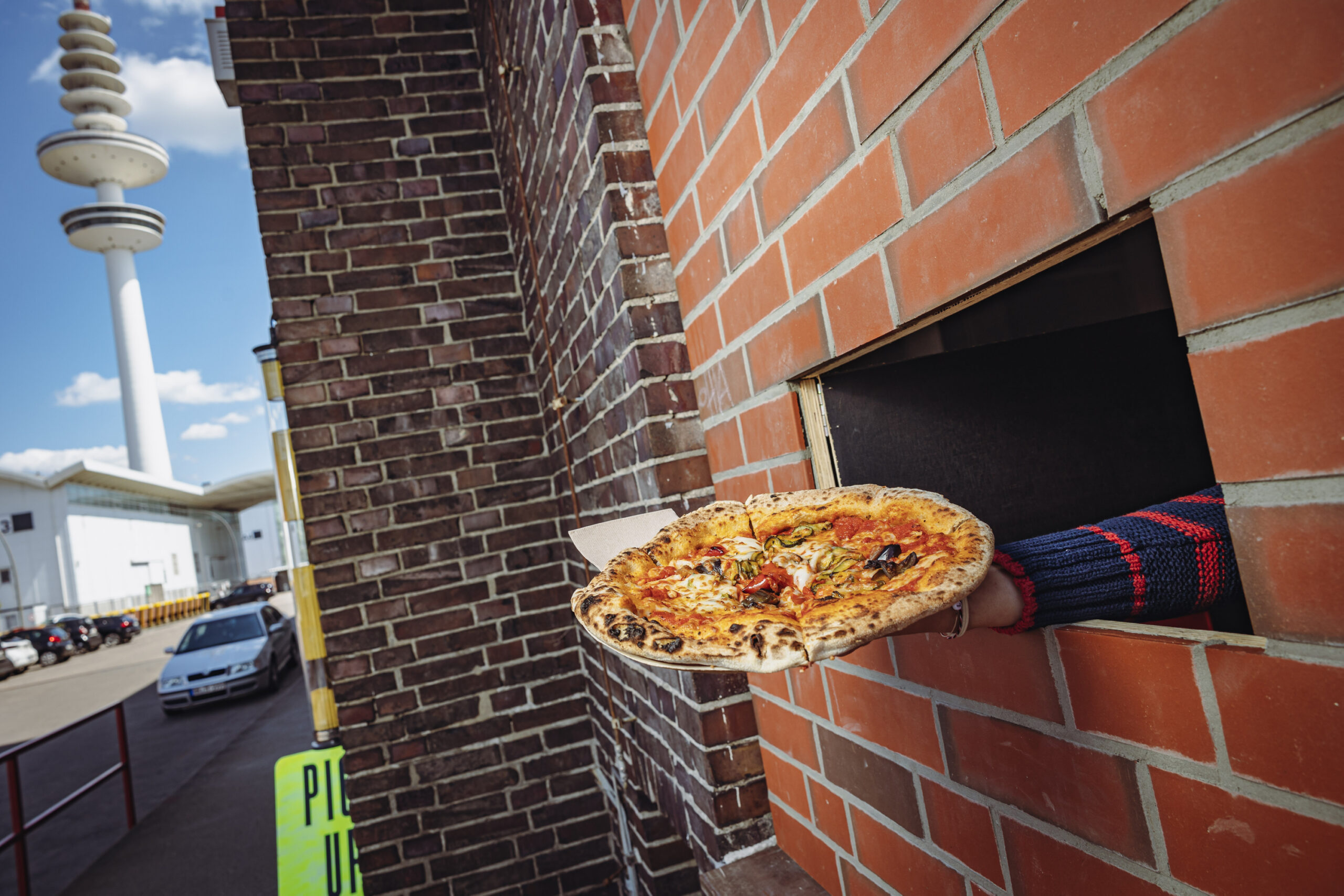 „Einmal vegetarisch, bitte!“: Die Pizza wird durch die Klappe gereicht.