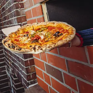 „Einmal vegetarisch, bitte!“: Die Pizza wird durch die Klappe gereicht.