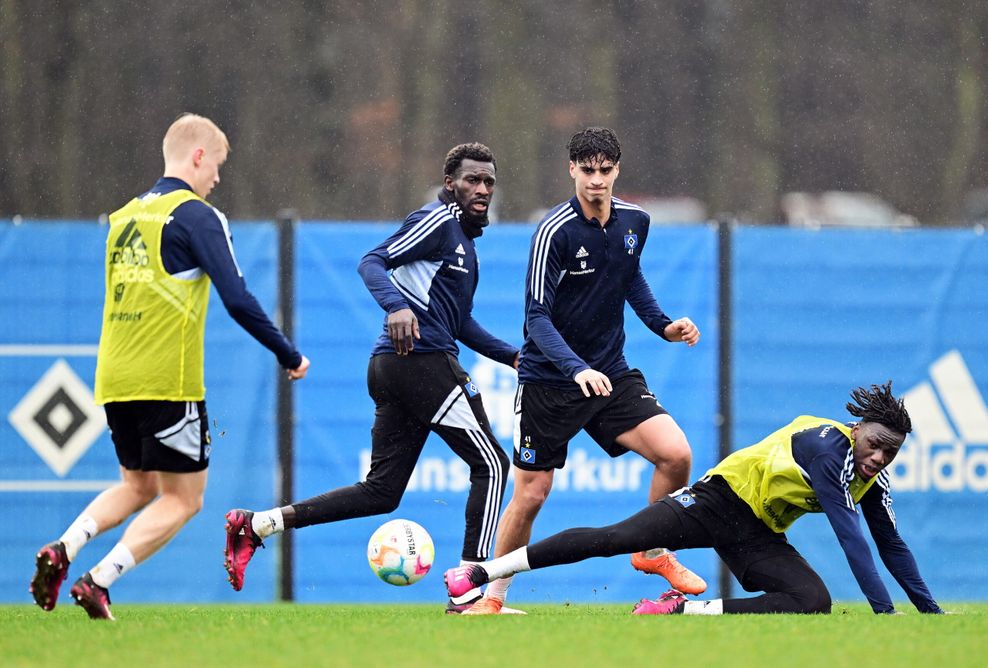 Fabio Baldé fällt im HSV-Training neben Bakery Jatta und Omar Megeed zu Boden