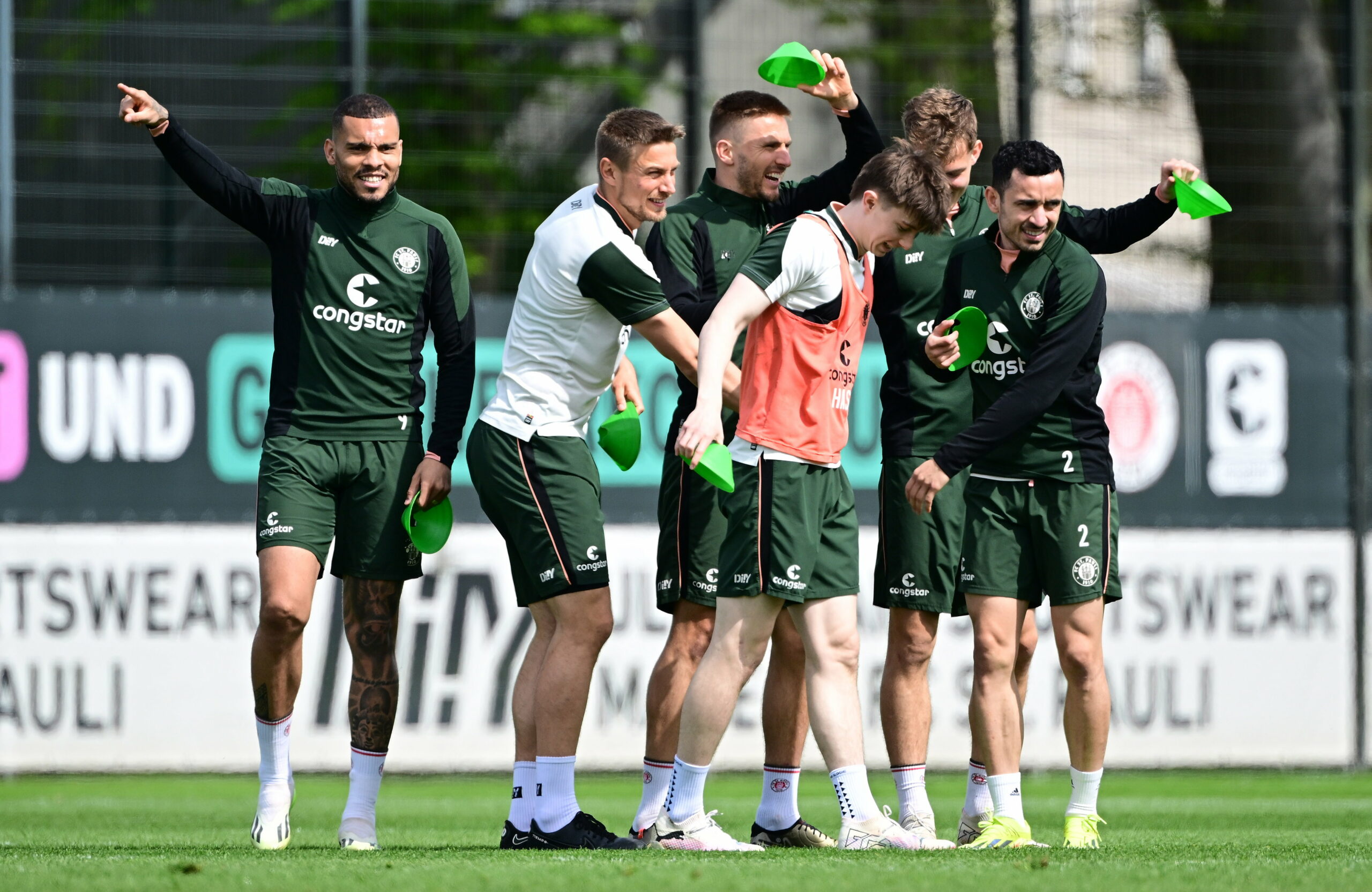 Maurides albert mit den Teamkollegen auf dem Trainingsplatz herum.