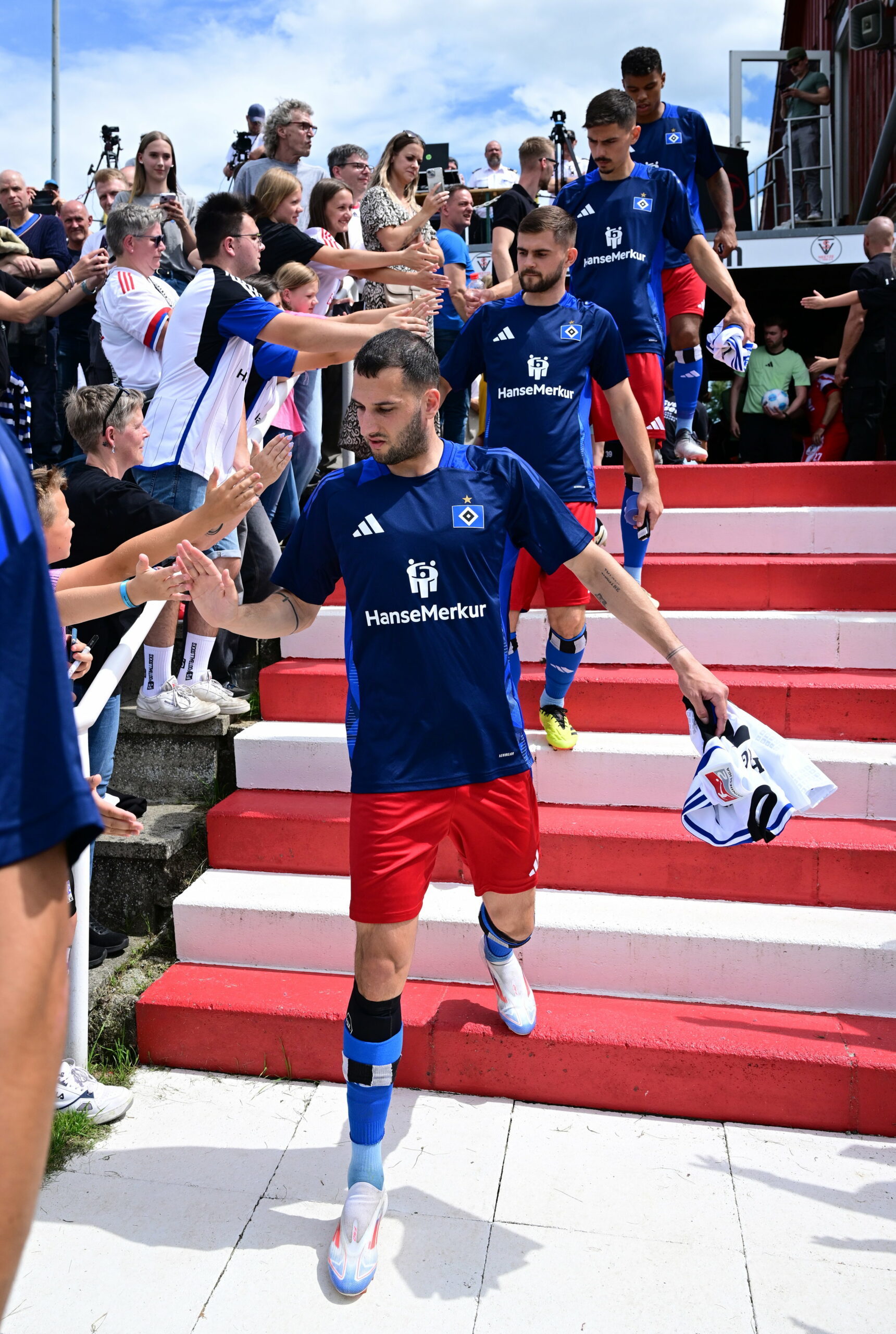 Levin Öztunali, Lukasz Poreba und Dennis Hadzikadunic klatschen mit HSV-Fans in Neetze ab