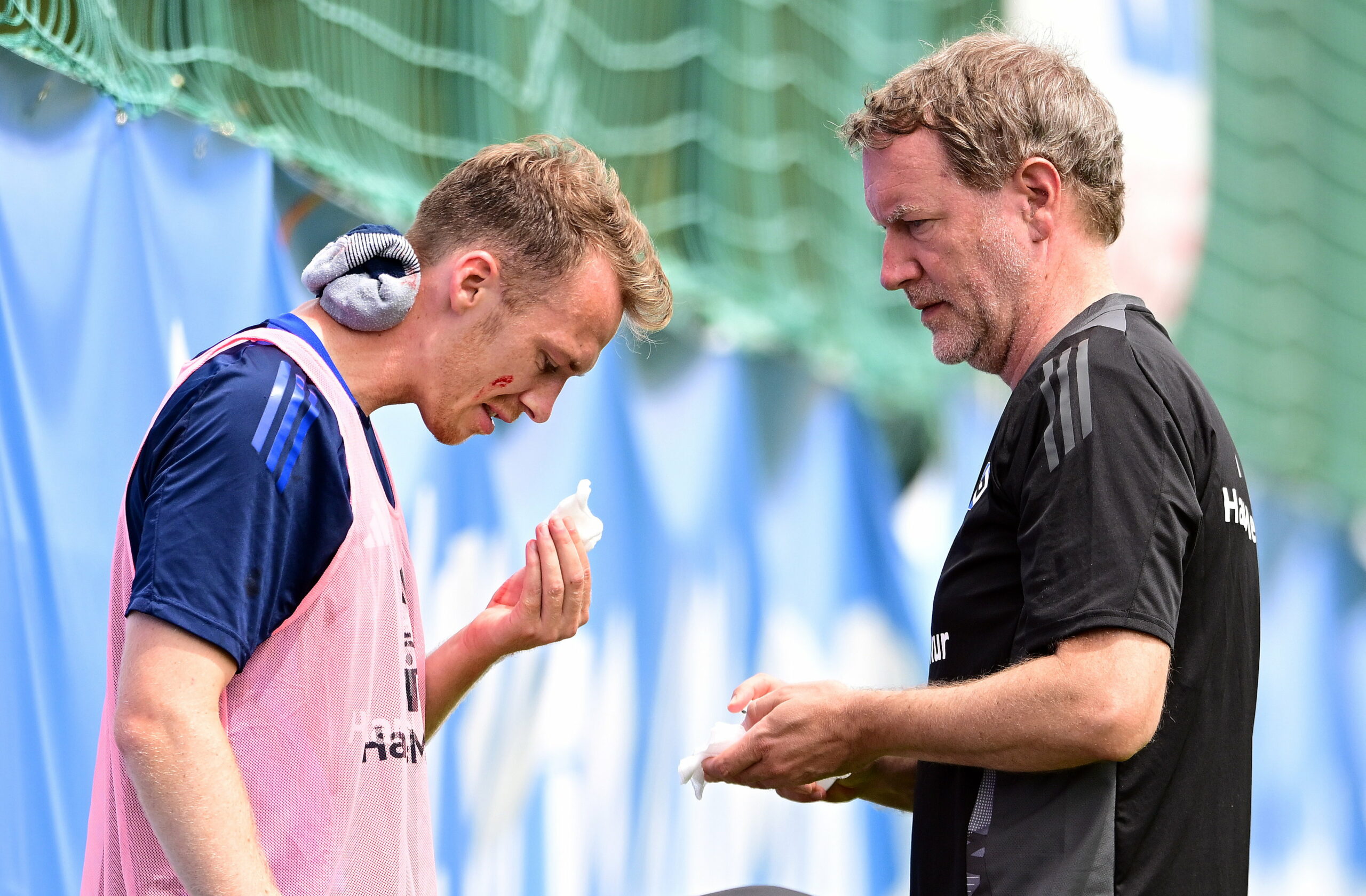 Sebastian Schonlau hat am Trainingsplatz eine blutige Nase, Mannschaftsarzt Dr. Götz Welsch versorgt ihn