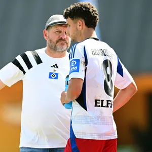 Steffen Baumgart spricht am Rande des HSV-Spiels gegen Aris Limassol mit Daniel Elfadli