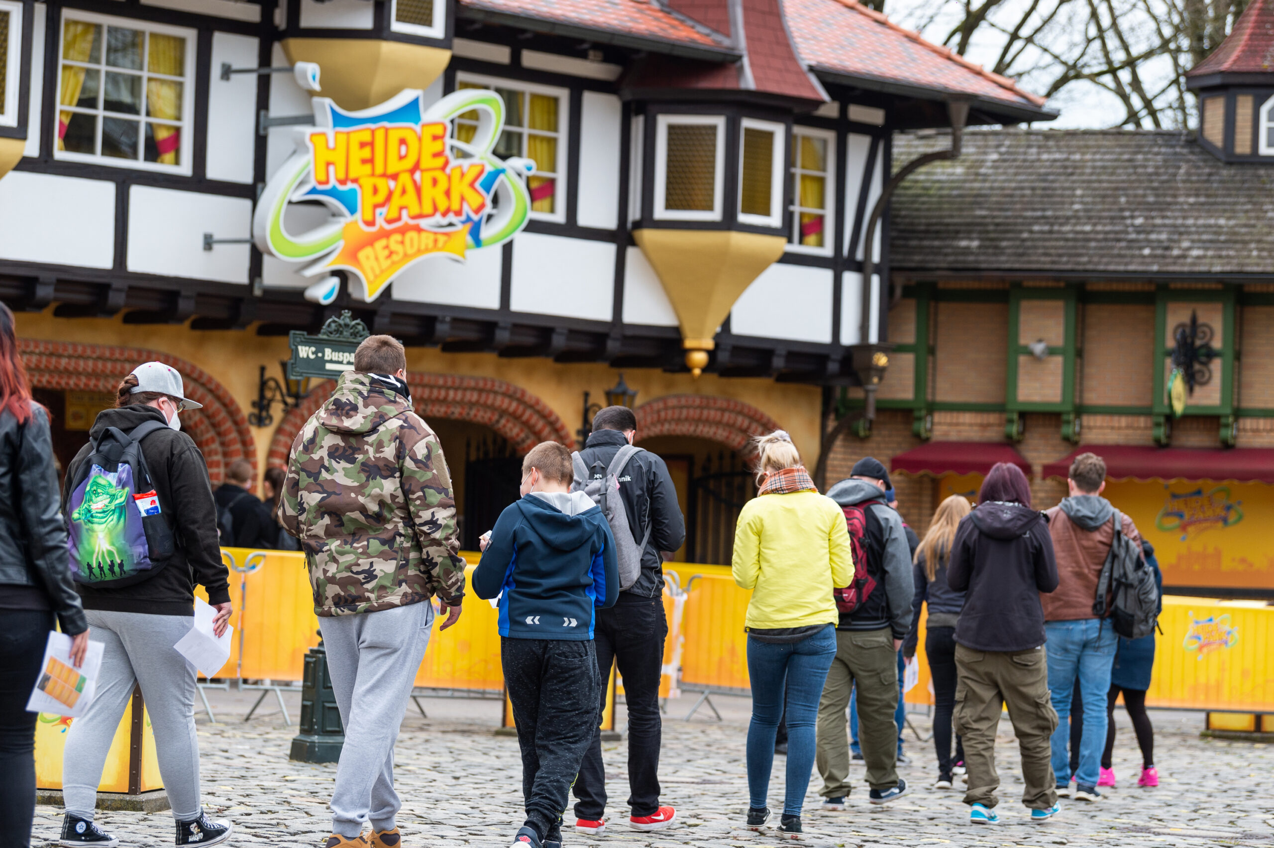 Besucher gehen zum Eingang vom Heide Park Resort.