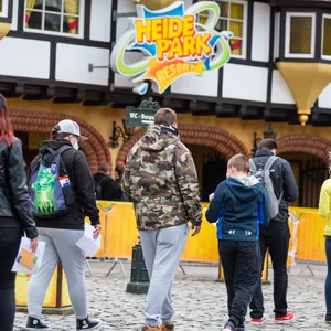 Besucher gehen zum Eingang vom Heide Park Resort.