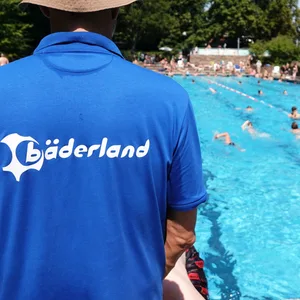 Bäderland-Bademeister von hinten vor einem Schwimmbecken