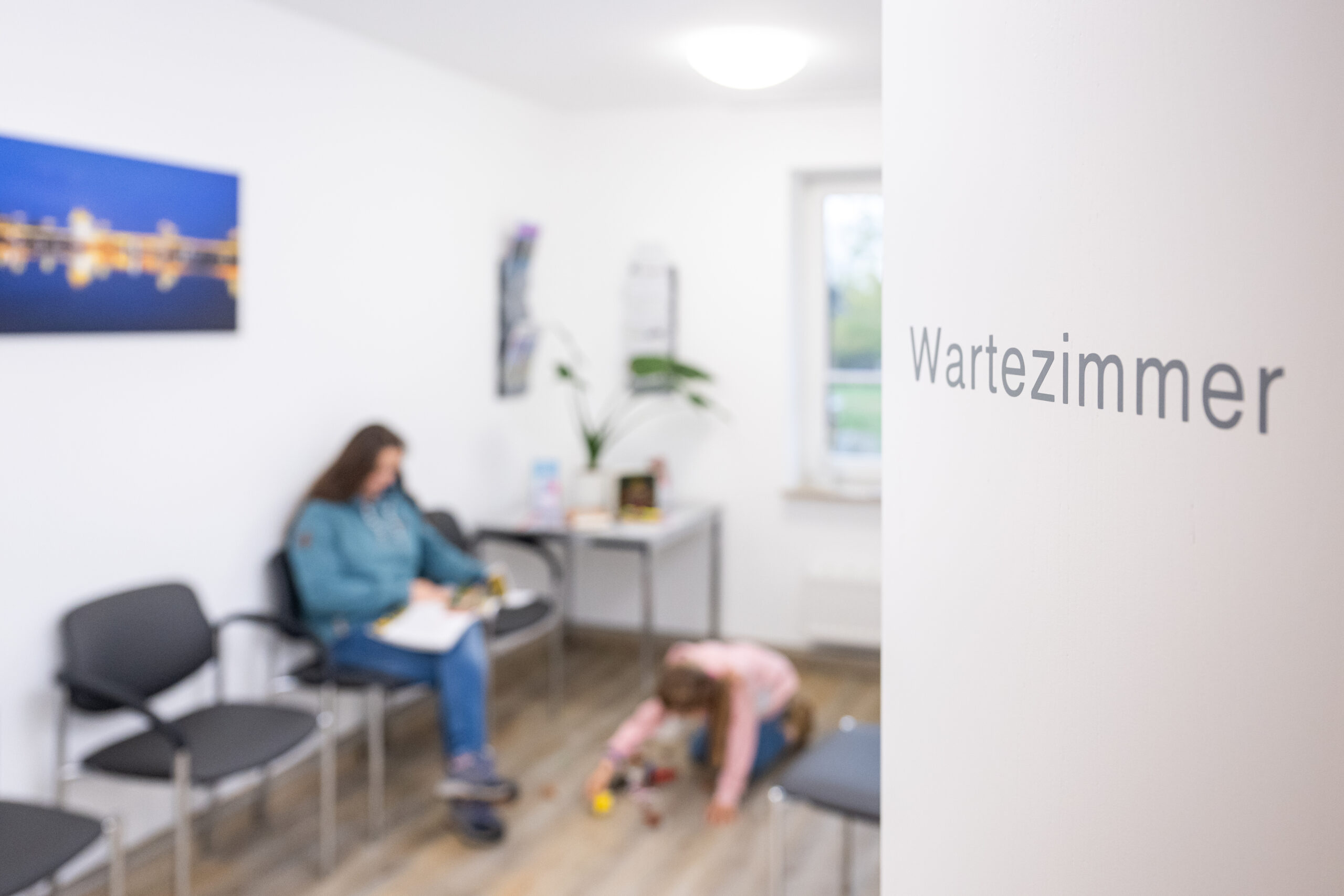 Patienten sitzen im Wartezimmer einer Arztpraxis.