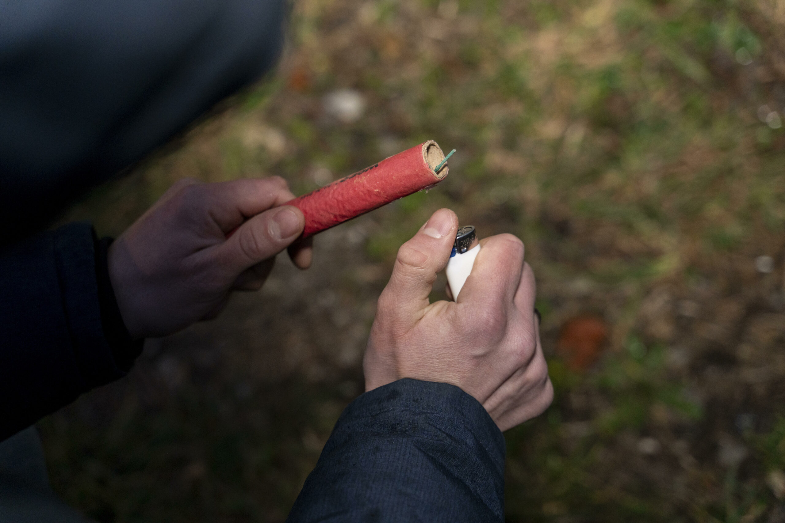 Hand zündet Böller mit Feuerzeug an