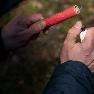 Hand zündet Böller mit Feuerzeug an
