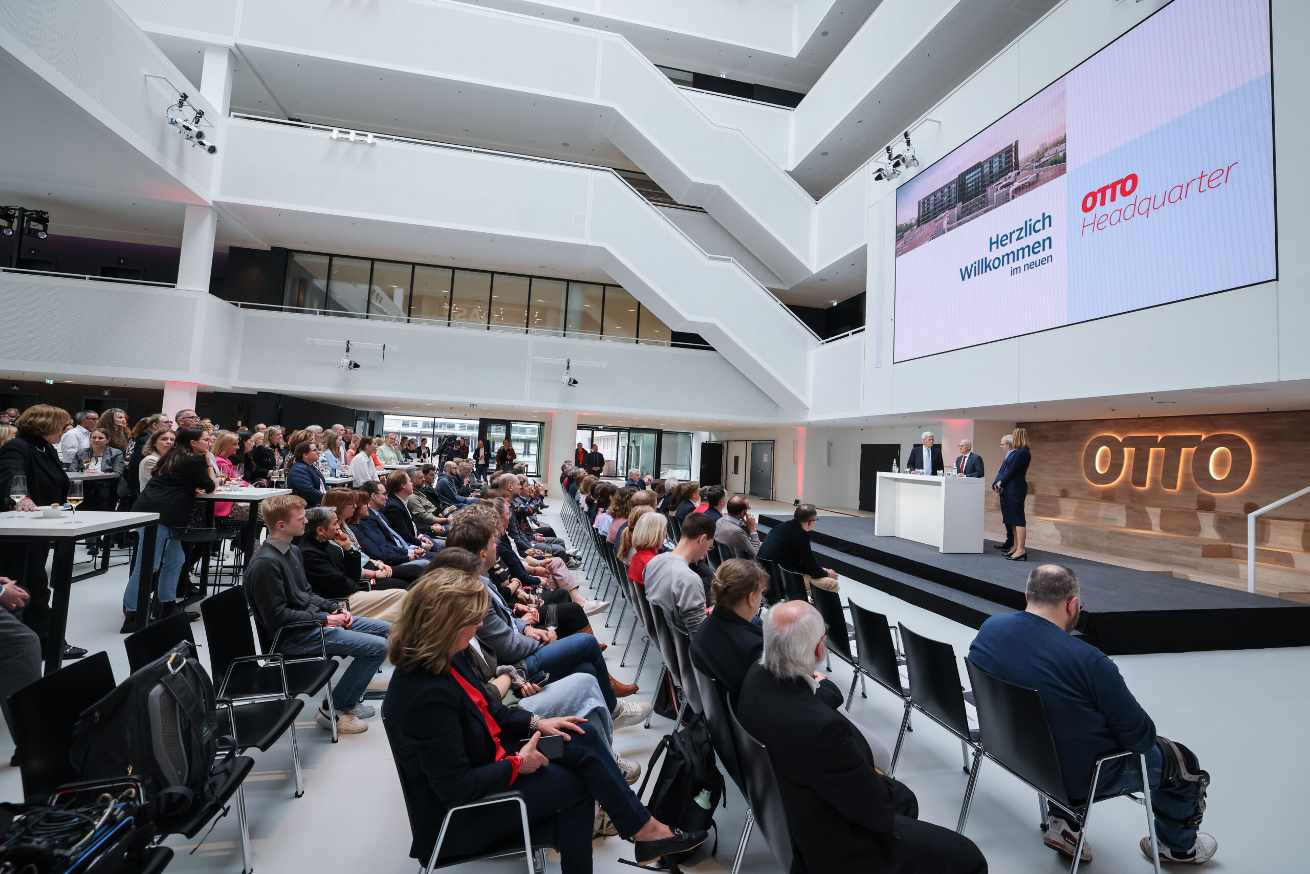 Menschen sitzen vor Podium im Otto-Headquarter