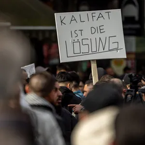 Demo mit Schild „Kalifat ist die Lösung“