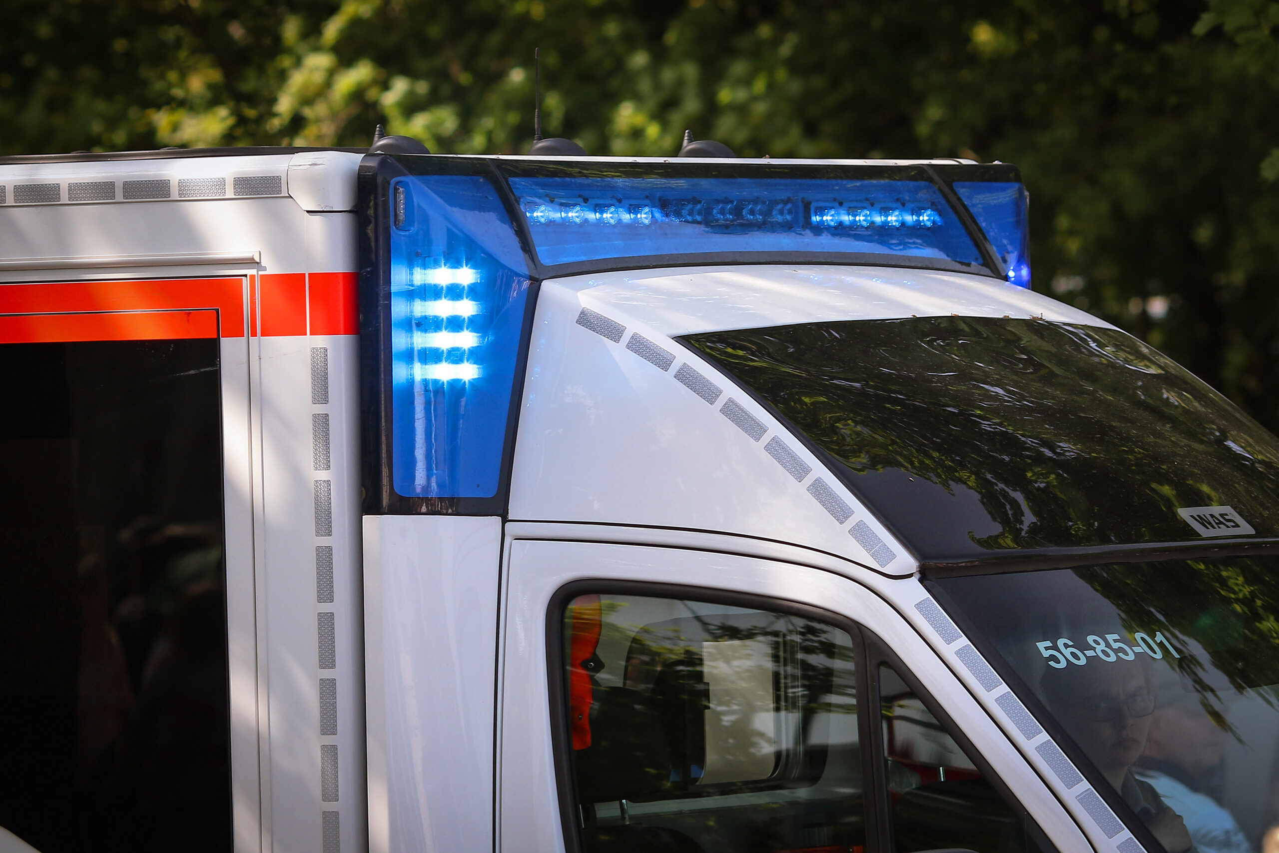 Ein Krankenwagen fährt mit Blaulicht durch eine Straße zum Einsatz.