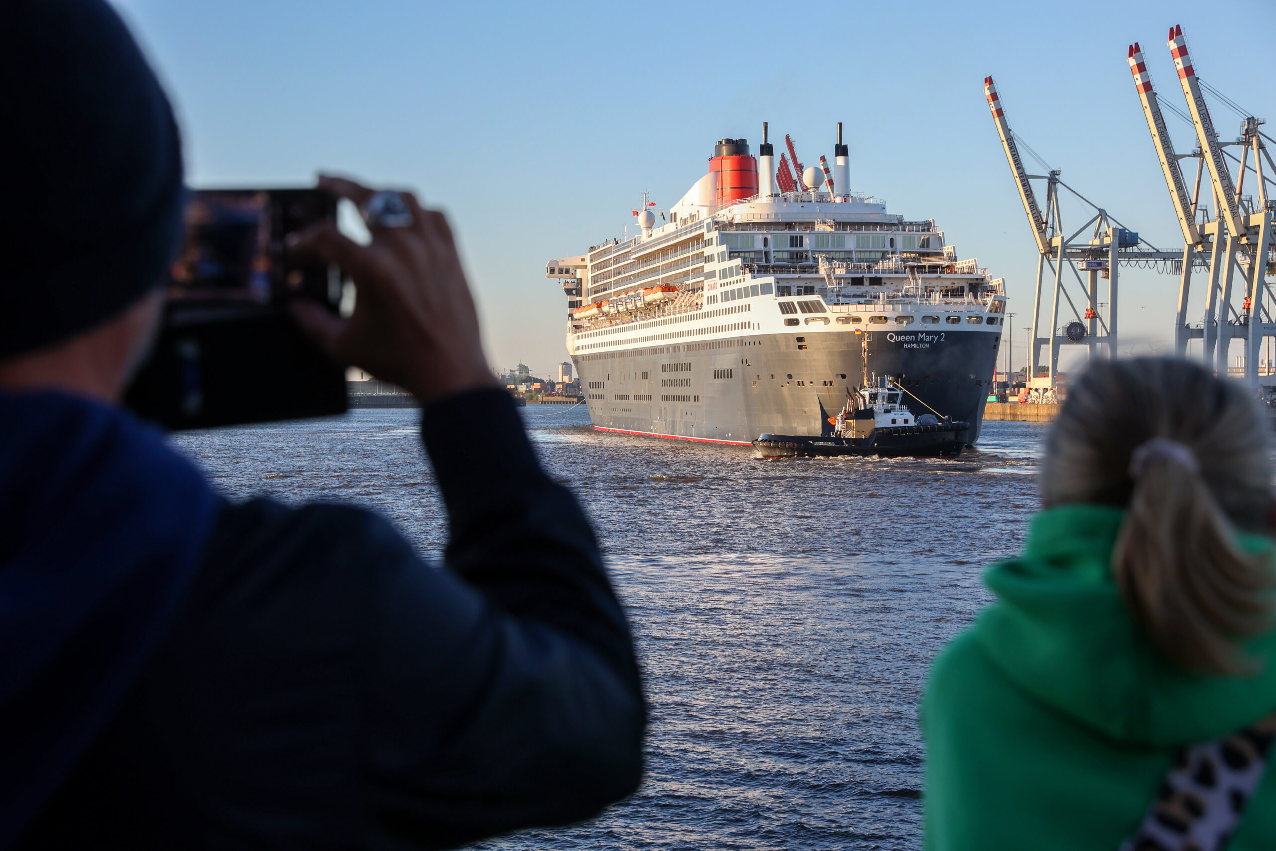 Das Kreuzfahrtschiff „Queen Mary 2“ läuft bei Sonnenschein am Morgen in den Hamburger Hafen ein.