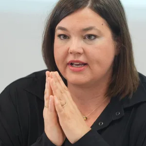 Frau mit dunklen Haaren, Hände unter dem Kinn