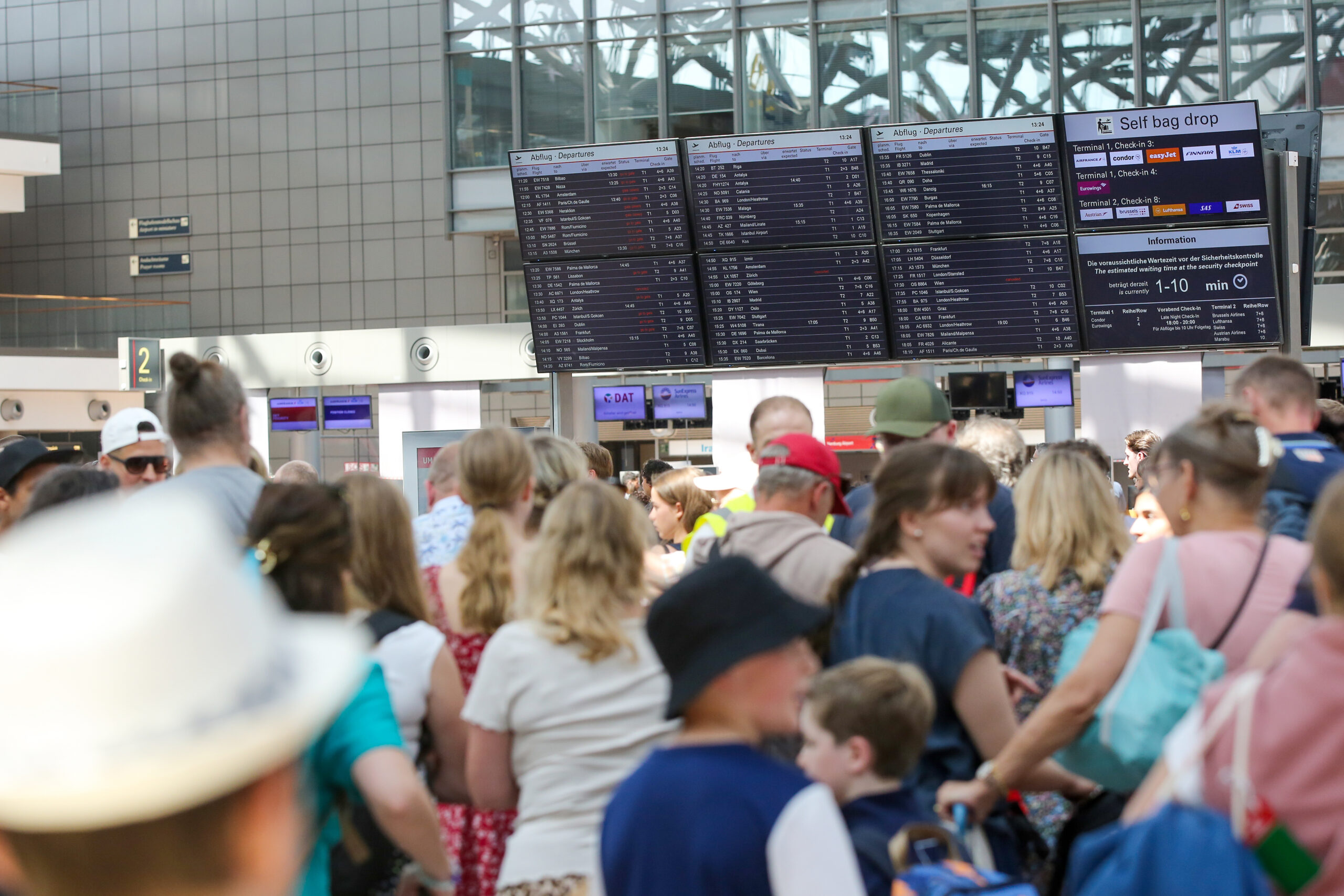 Zahlreiche Reisende stehen am Terminal 1 am Hamburger Flughafen.