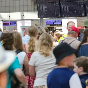 Zahlreiche Reisende stehen am Terminal 1 am Hamburger Flughafen.