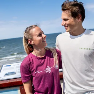 Vivien Wolfs und Kilian Stegmann stehen auf einer Aussichtsplattform am Strand der Insel.