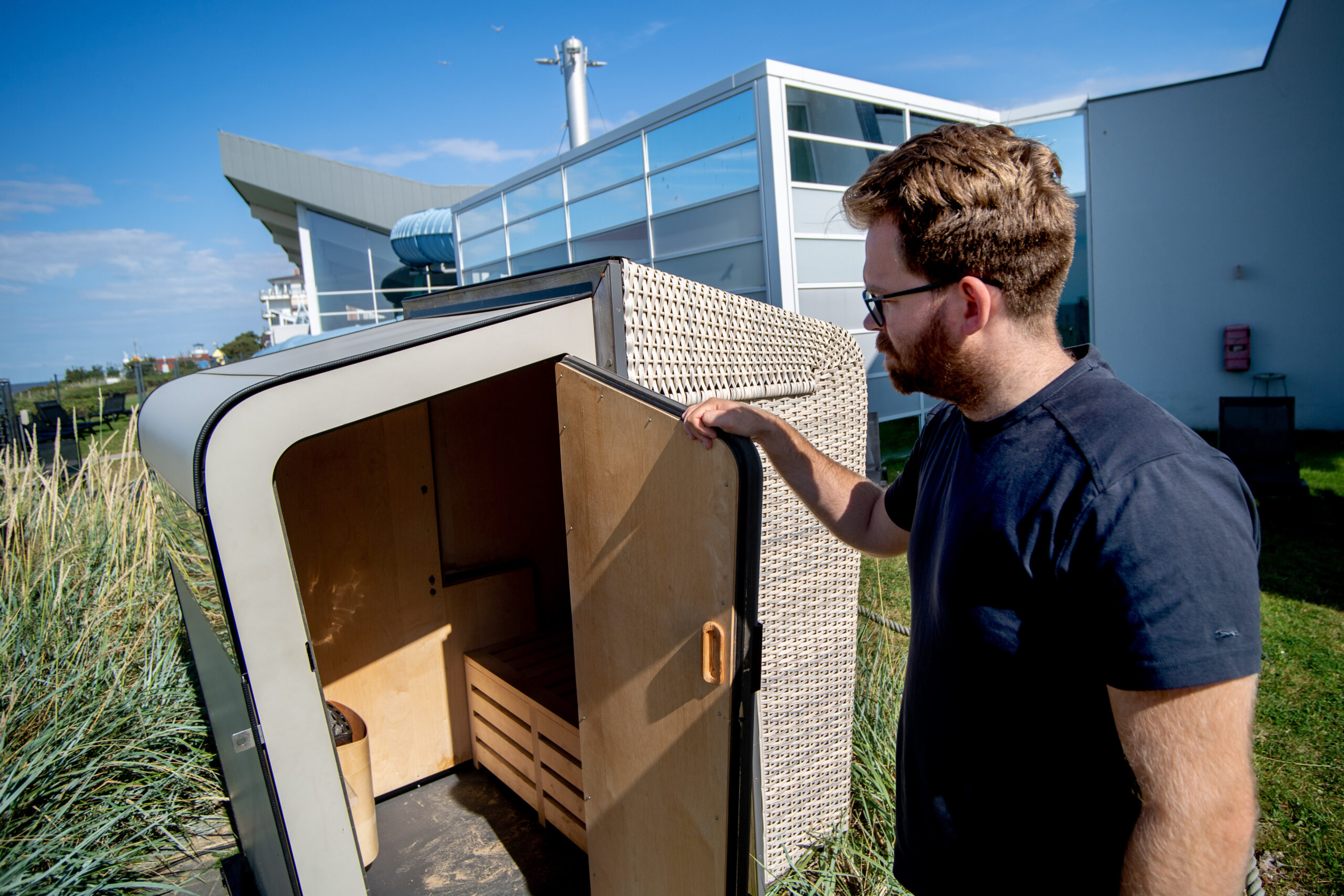 Jannik Busse, Teamleiter im Bereich Marketing der Nordseeheilbad Cuxhaven GmbH, öffnet eine Strandkorbsauna im Außenbereich des Thalassozentrums „Ahoi“ im Ortsteil Duhnen.