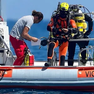 Ein Taucher der italienischen Feuerwehr macht sich auf einem Schlauchboot für einen Tauchgang bereit.