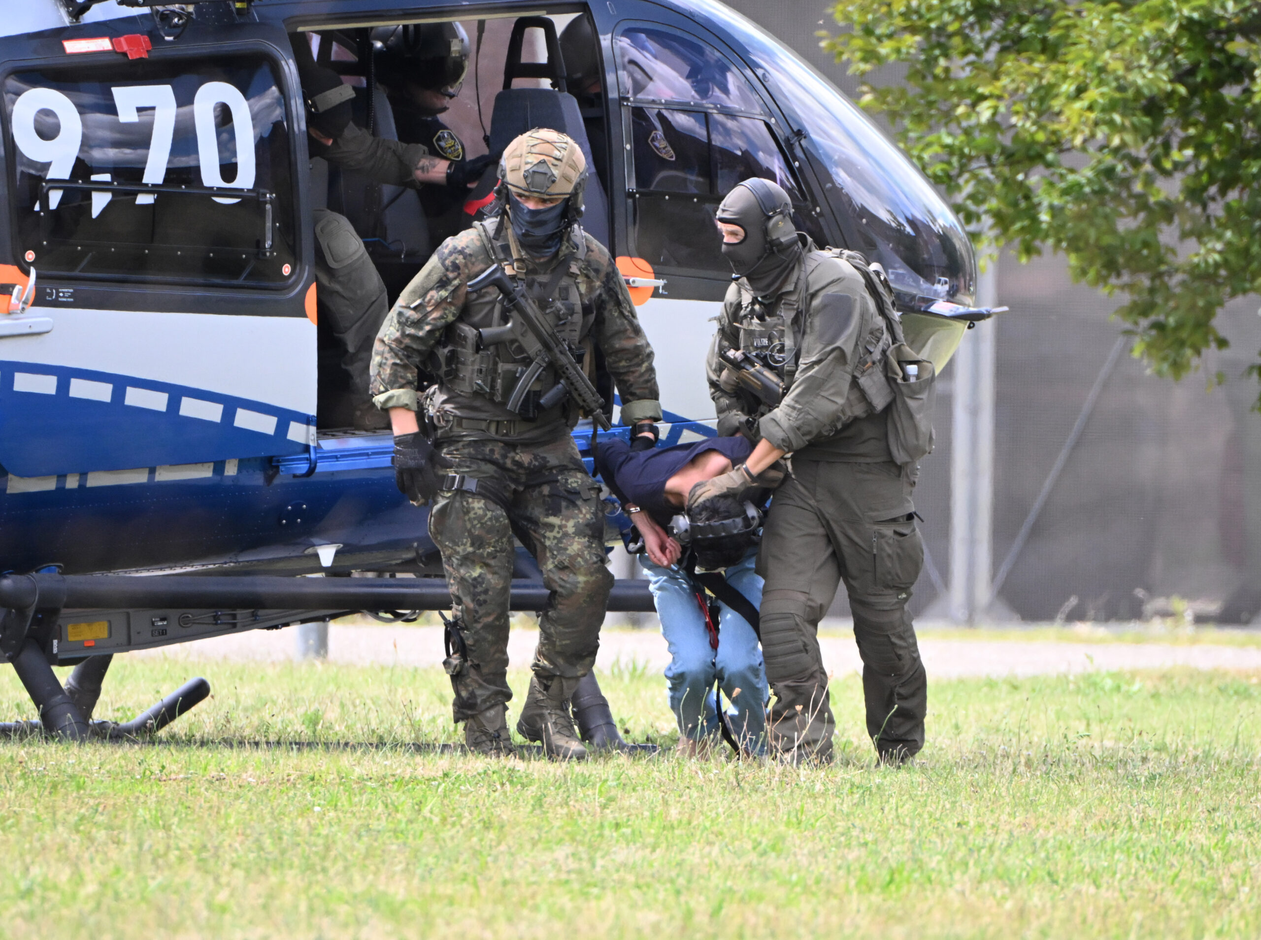 Der mutmaßliche Täter des Messerangriffs von Solingen wird von einem Hubschrauber zu einer Wagenkolonne geführt.