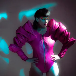 Dunkles Foto, Peaches trägt einen pinkfarbenen Body mit puffigen Ärmeln