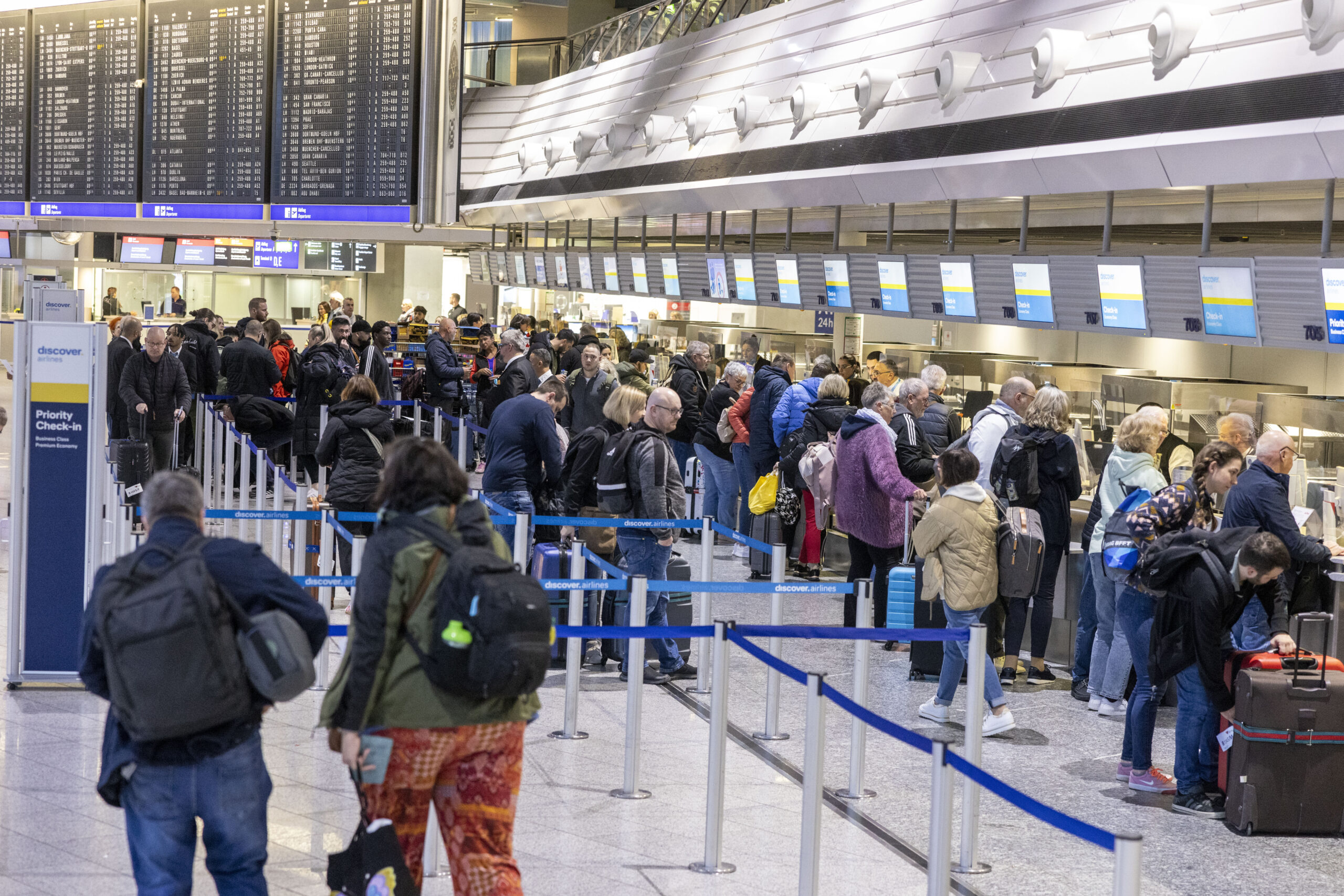 Reisende stehen an den Abfertigungsschaltern von „Discover Airlines“. (Symbolbild)