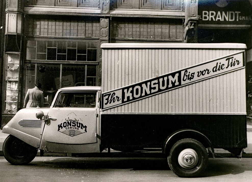 Ein Tempo Hanseat Dreirad-Kastenwagen mit der Aufschrift „Ihr Konsum bis vor die Haustür“.