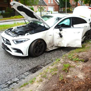 Der schwer beschädigte Mercedes steht am Straßenrand.
