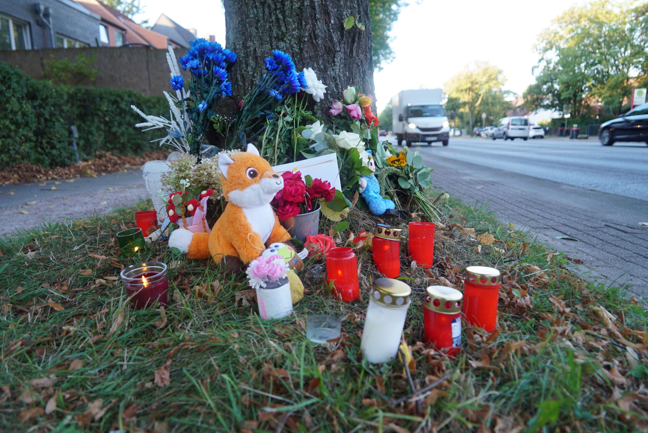 Trauernde Menschen haben nach dem tödlichen Unfall am Schiffbeker Weg Kerzen, Blumen und Kuscheltiere niedergelegt.