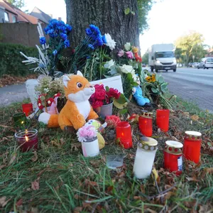 Trauernde Menschen haben nach dem tödlichen Unfall am Schiffbeker Weg Kerzen, Blumen und Kuscheltiere niedergelegt.