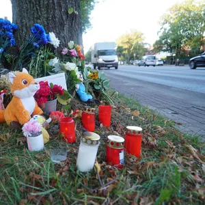 Trauernde Menschen haben nach dem tödlichen Unfall am Schiffbeker Weg Kerzen, Blumen und Kuscheltiere niedergelegt.