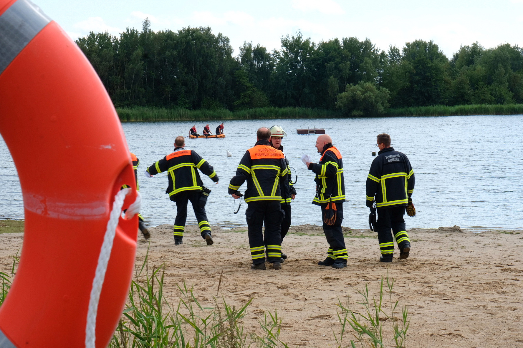 Feuerwehrleute am Strand des Badesees