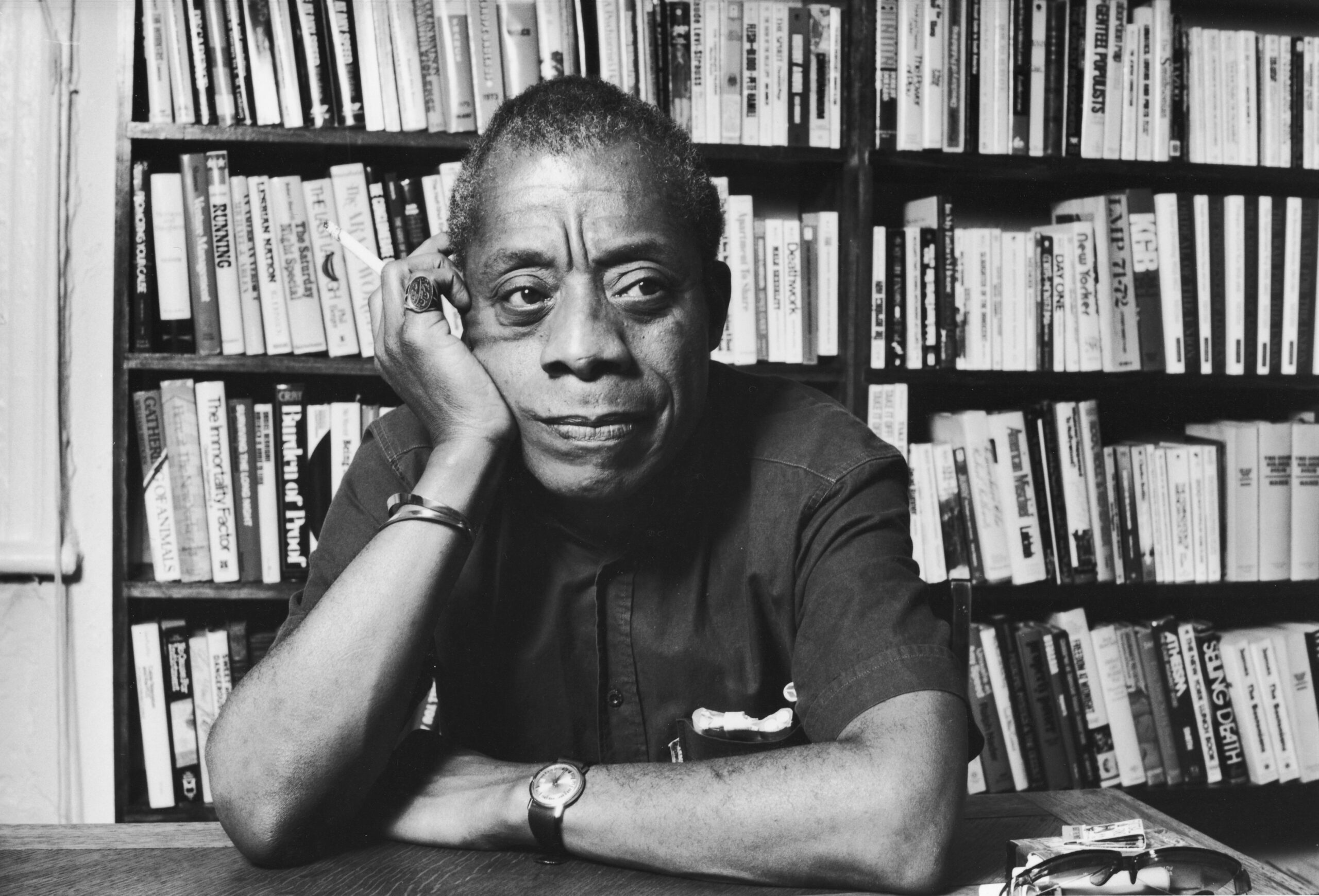 James Baldwin sitzt an seinem Schreibtisch.