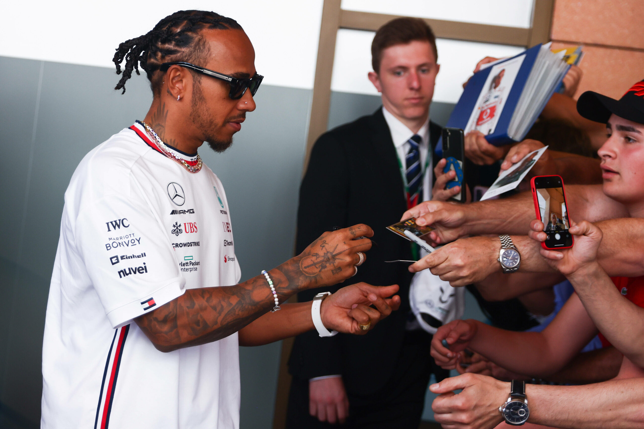 Lewis Hamilton unterschreibt Autogramme.